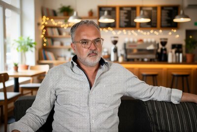 Autor W.H. Hartmann sitzt gem&uuml;tlich in einem Caf&eacute;.